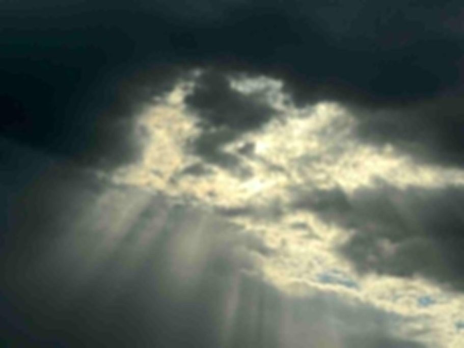 Dunkle Wolken mit vereinzelten Lichtstrahlen, die durchscheinen.