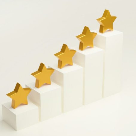 Fünf goldene Sterne auf weißen Säulen, die Fortschritt symbolisieren.