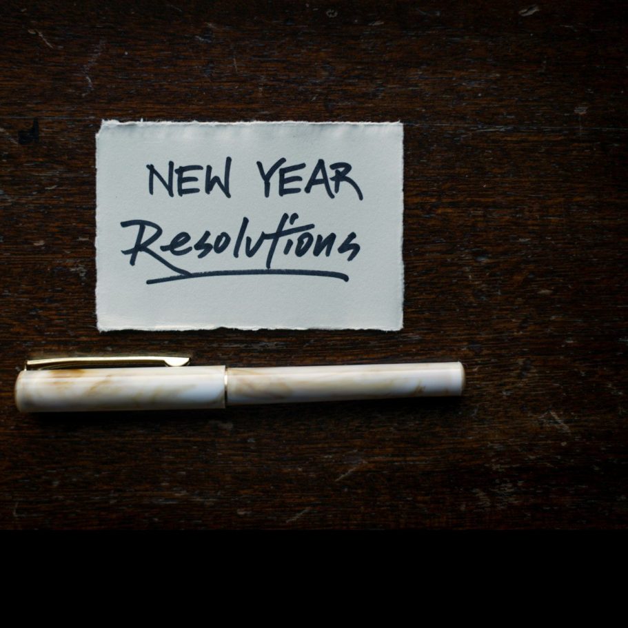 Auf einem Tisch liegt ein Stift neben einer Notiz mit "Neujahrsvorsätze".